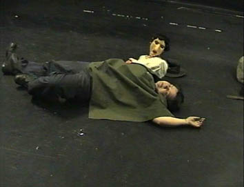 Agnes [played by an actor] lies asleep on the ground. Matilda [ a puppet] is watching her as she sleeps.